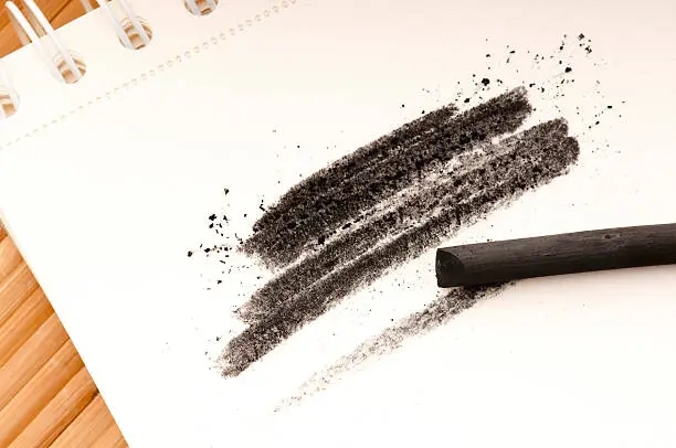 charcoal stick with black strokes on paper